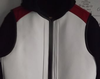 May include: A white leather vest with a black zipper and black sleeves. The vest has a red trim around the neck and shoulders. The vest has a hood.