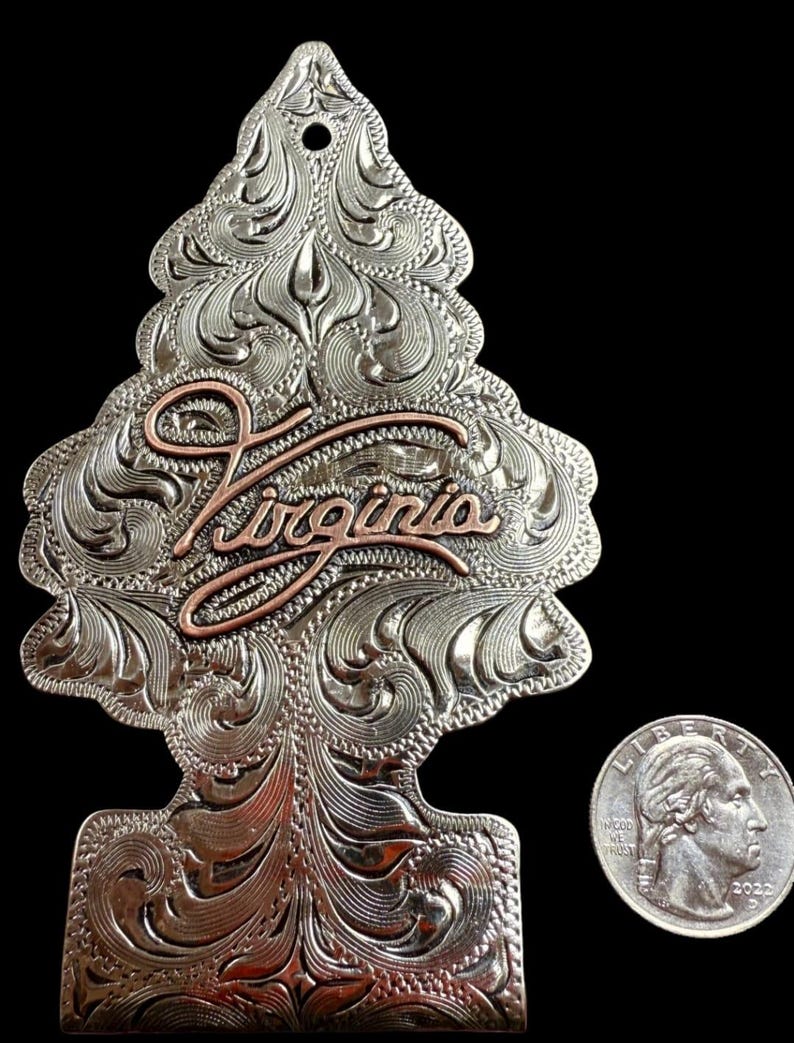 Peut inclure: Ornement en m&eacute;tal argent&eacute; en forme de sapin de No&euml;l, avec des volutes florales complexes et le mot "Virginia" en script cuivr&eacute;. Une pi&egrave;ce de monnaie am&eacute;ricaine est &agrave; c&ocirc;t&eacute; de l'ornement pour la comparaison de taille.