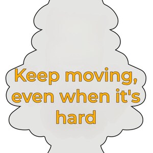 Peut inclure: Un d&eacute;sodorisant gris clair en forme d'arbre, avec le texte orange "Keep moving, even when it's hard". Il comporte un trou en haut pour &ecirc;tre suspendu. Id&eacute;al pour une voiture.