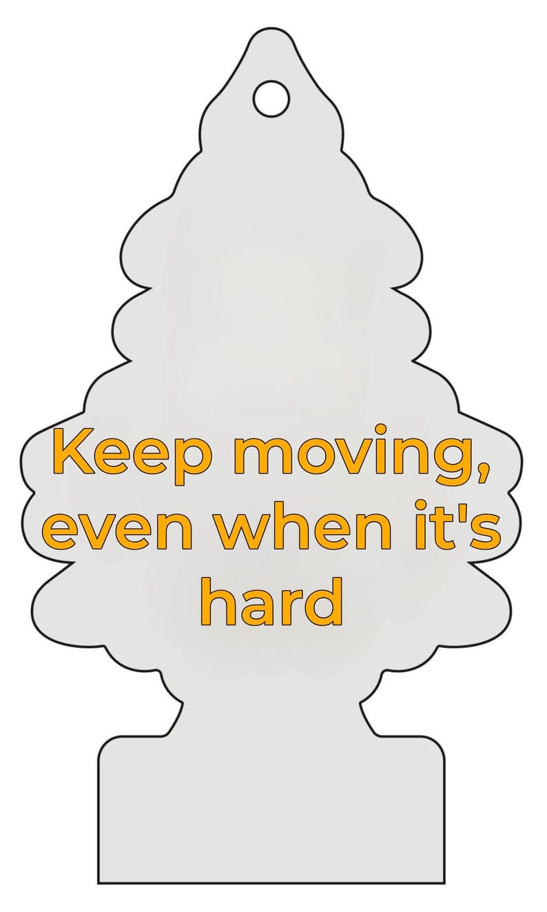 Peut inclure: Un d&eacute;sodorisant gris clair en forme d'arbre, avec le texte orange "Keep moving, even when it's hard". Il comporte un trou en haut pour &ecirc;tre suspendu. Id&eacute;al pour une voiture.