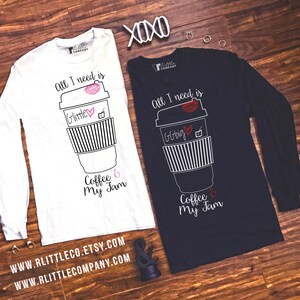 May include: Two long-sleeved shirts with a coffee cup graphic and the text "All I need is Coffee & My Jam". The shirts are white and navy blue. The text on the white shirt is in black and the text on the navy blue shirt is in white.