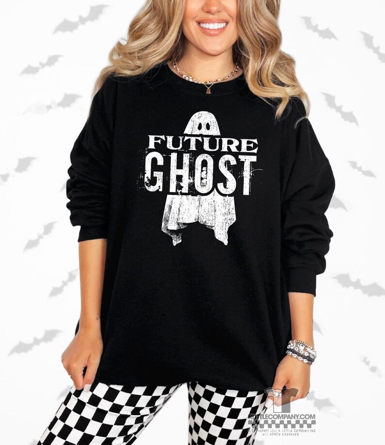 May include: Black long-sleeve sweatshirt with the text "FUTURE GHOST" and a ghost graphic. The sweatshirt is worn with black and white checkered pants. The image has a Halloween theme.