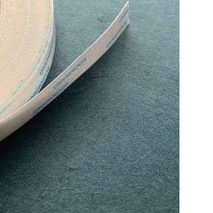 Pu&ograve; includere: Un rotolo di nastro adesivo a doppio lato bianco con testo blu che recita "SOOKWANG" sul nastro. Il nastro &egrave; largo 1,27 cm.