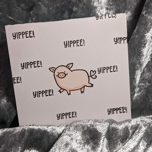 May include: A white card with a pink pig illustration and the text "YIPPEE!" repeated multiple times.