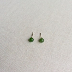 Puede incluir: Un par de pendientes de jade verde con postes de plata.