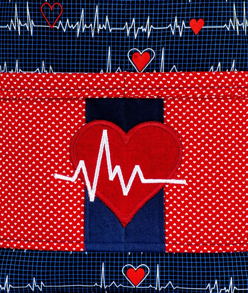 Peut inclure: Tissu rouge &agrave; pois blancs et tissu bleu avec un c&oelig;ur rouge et une ligne EKG blanche. Le tissu est cousu ensemble pour cr&eacute;er une poche.
