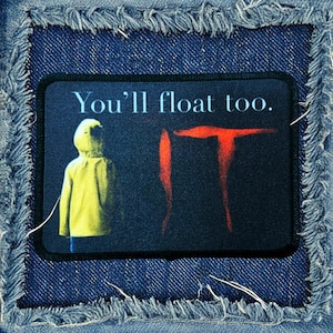 May include: A black and red patch with the word "IT" in red and the text "You'll float too." in white. A figure in a yellow raincoat is standing to the left of the word "IT".