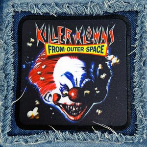 May include: A black and white patch with a scary clown face and the text "Killer Klowns From Outer Space".