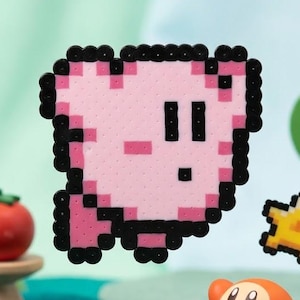 May include: A pixel art figure of a pink character with black outlines, positioned above a small orange round creature. A yellow star-shaped piece floats nearby. The scene includes a green felt tree with fruit and a red tomato on a stand.