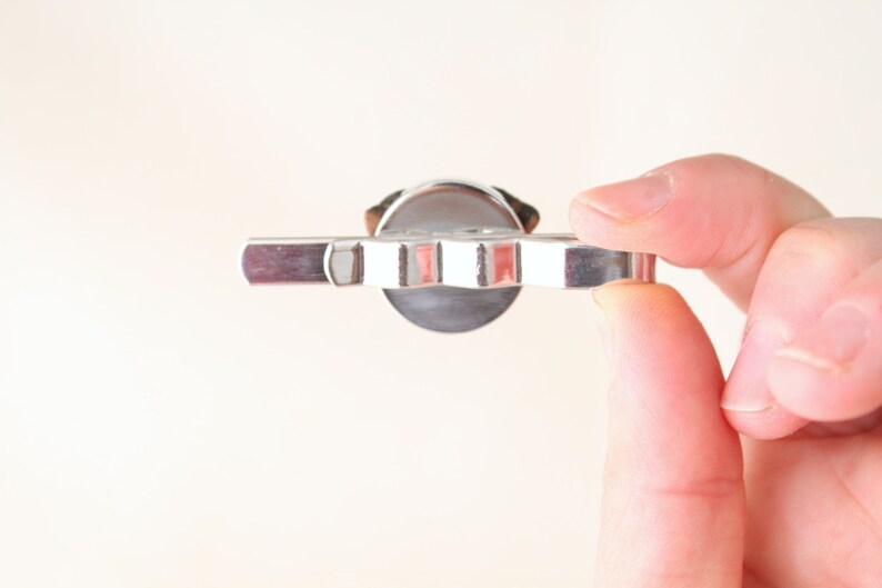 May include: A silver-toned key with a star-shaped head and a flat, rectangular handle.