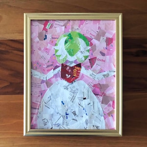 May include: Framed artwork featuring a collage of paper scraps in pink, white, red, and green. The artwork depicts a figure with a white top, a red face, and a green head covering. The frame is gold-colored.
