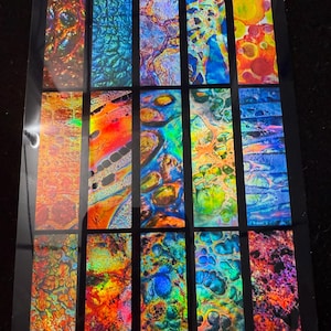 May include: A sticker sheet with a holographic design. The sheet is divided into rectangular sections with vibrant, abstract patterns in shades of orange, blue, green, and purple. The text "HOLO FUSION BEZEL INLAY STYLE 2 STICKER SHEET" is at the top.