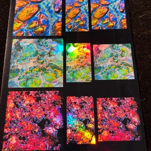 May include: A sticker sheet with nine holographic stickers featuring abstract designs in various colors, including blue, green, red, and yellow. The sheet is labeled "Holo Fusion Film Inlay Set 1" and "Sticker Sheet" with the company name "Artful-Elements".