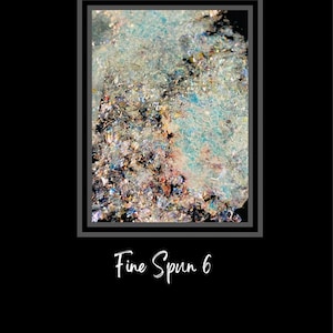 May include: Close-up of a teal, blue, and silver iridescent glitter. The glitter is in a frame with the text "Fine Spun 6" below the frame.