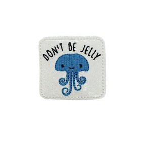 May include: White iron-on patch with a blue cartoon jellyfish and the text "Don't Be Jelly".