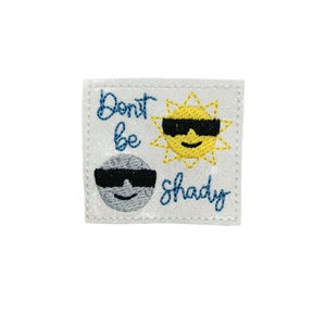 May include: White embroidered patch with a sun and moon wearing sunglasses. The text reads "Don't be shady".