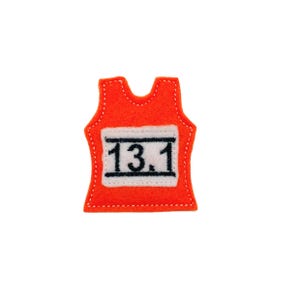 May include: Orange felt running bib with white felt number "13.1" in black embroidery.