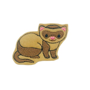 May include: A brown and white embroidered ferret patch with pink ears and nose. The ferret is sitting on its haunches with its tail curled behind it.