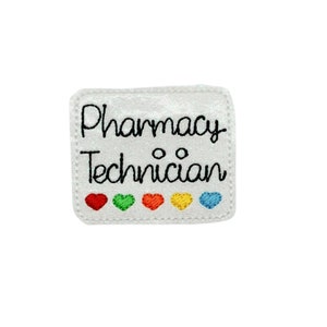 May include: White embroidered patch with the text "Pharmacy Technician" in black cursive font. Five small embroidered hearts in red, green, orange, yellow, and blue are below the text.