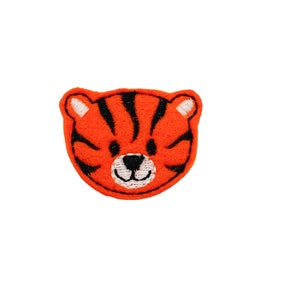 May include: Orange felt tiger face applique with black stripes and white eyes.