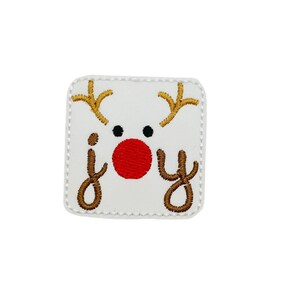 May include: White felt square patch with embroidered reindeer face and the word "joy" in brown thread. The reindeer has a red nose and black eyes.