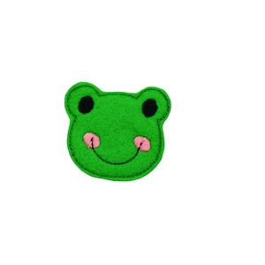 May include: Green felt frog face applique with black eyes and a pink smile.