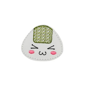 May include: White embroidered patch of a cartoon onigiri, a Japanese rice ball, with a green seaweed topping and a cute face with pink cheeks.