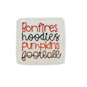 May include: White square patch with the words "Bonfires", "hoodies", "pumpkins", and "football" embroidered in red, black, orange, and brown thread.