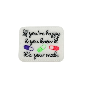 May include: White felt patch with black embroidered text that reads "If you're happy & you know it it's your meds". There are three colorful pills embroidered below the text.