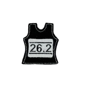 May include: Black running bib with white stitching and the number 26.2 embroidered on it.