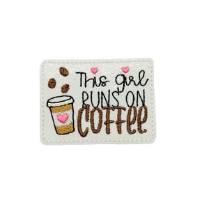 May include: White embroidered patch with brown coffee cup, coffee beans, and pink hearts. The text reads "This girl runs on coffee".