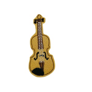 May include: A brown felt applique of a violin with a black and white string design.