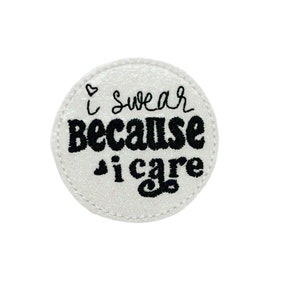 May include: White round patch with black embroidered text that reads "I swear because I care" with a small heart above the "I".