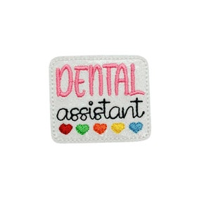 May include: White embroidered patch with pink text that reads "DENTAL assistant" and a row of five small hearts in rainbow colors.