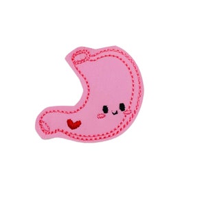 May include: Pink felt stomach with a red heart and a smiling face. The stomach is outlined in red thread.