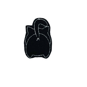 May include: Black felt cat applique with a white outline. The cat is facing away from the viewer with its tail curled over its back.