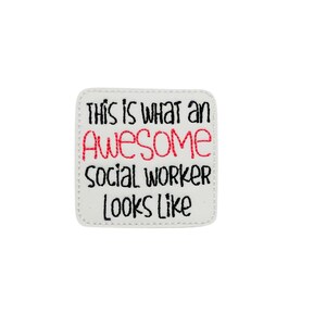 May include: White square patch with black stitching around the edges. The text "This is what an awesome social worker looks like" is embroidered in black and red thread.