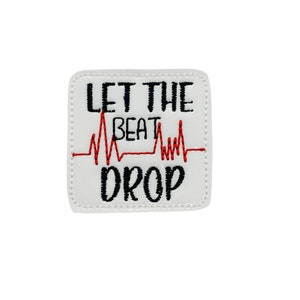 May include: White square patch with black embroidered text that reads "LET THE BEAT DROP". A red heartbeat line is embroidered between the words "BEAT" and "DROP". The patch has a white border with a dotted stitch.