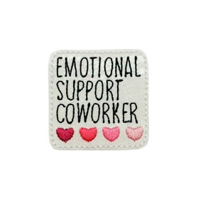 May include: White patch with black text that reads "Emotional Support Coworker" with four pink hearts below the text.