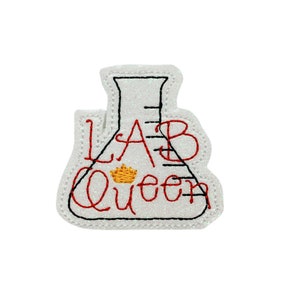 May include: White embroidered patch with a beaker and the text "LAB Queen" in red with a gold crown above the word "Queen".