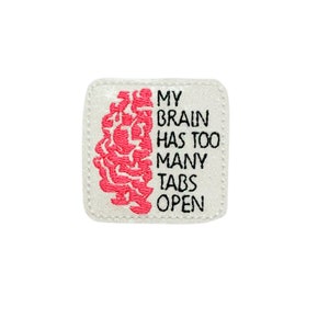 May include: White square patch with pink embroidered brain and black text that reads "My brain has too many tabs open".