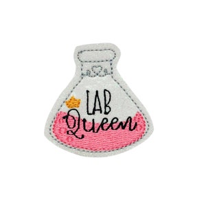 May include: White and pink embroidered iron-on patch with a beaker and the text "Lab Queen".