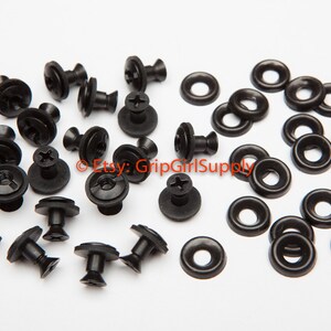 May include: A close-up of black plastic fasteners and washers. There are 18 fasteners and 20 washers. The fasteners have a screw head and a round base. The washers are round with a hole in the center.