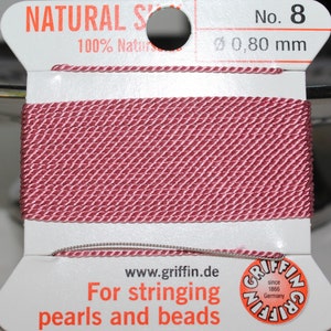 May include: Spool of natural silk string, color is a muted rose. The label reads "NATURAL SILK" and "100% Natural". The string is 0.80 mm in diameter. The label also says "For stringing pearls and beads".