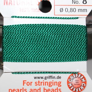 May include: A spool of emerald green natural silk thread, 0.80 mm in diameter, for stringing pearls and beads. The label reads "NATURAL SILK" and "Griffin" with the text "For stringing pearls and beads."
