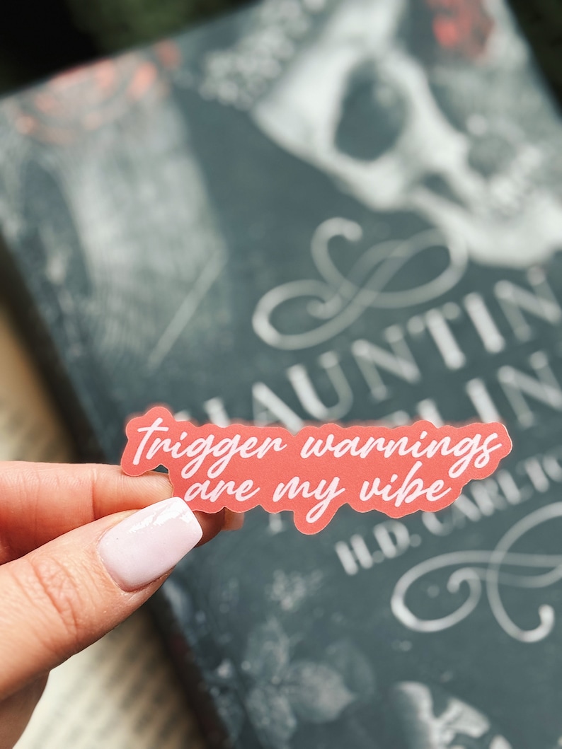 May include: A pink sticker with white text that reads 'trigger warnings are my vibe'.