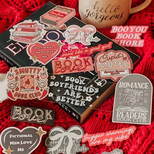 Puede incluir: Una colecci&oacute;n de pegatinas coloridas con dise&ntilde;os de tem&aacute;tica de libros. Las pegatinas incluyen frases como "Good Girl Book Club", "Book Boyfriend Are Better", "Smutty Book Club", "Trigger Warnings Are My Vibe", y "Dark Romance Is The Vibe".
