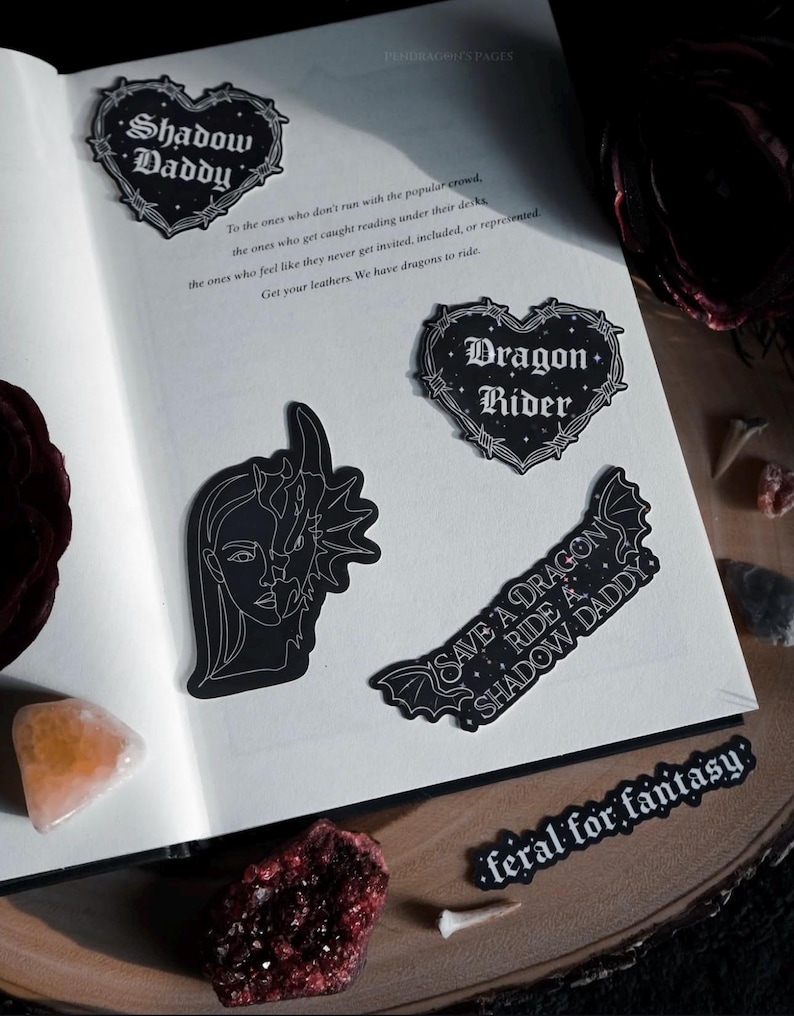 May include: Four black and white stickers with gothic-style text and imagery. The stickers feature the phrases "Shadow Daddy", "Dragon Rider", "Save a Dragon Ride a Shadow Daddy", and "Feral for Fantasy".