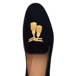 May include: Black velvet slippers with gold embroidered tassels.