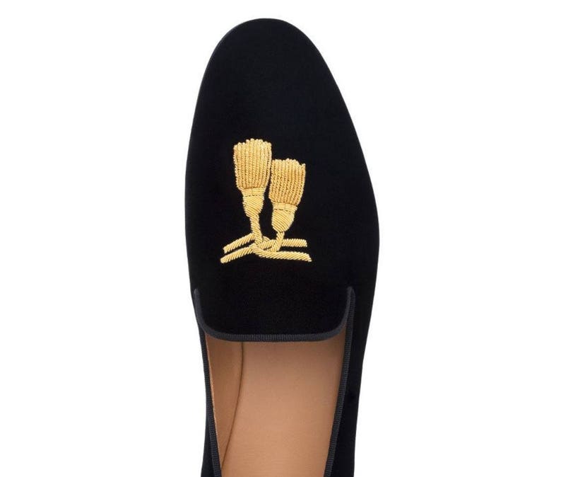 May include: Black velvet slippers with gold embroidered tassels.